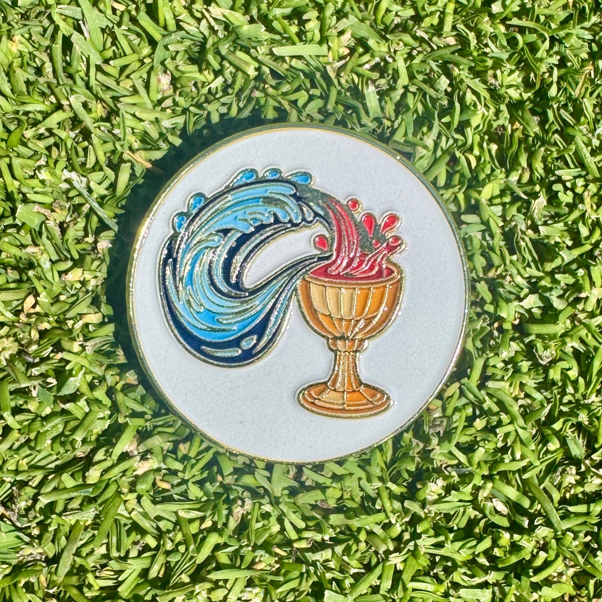 Decorative golf ball marker with a colorful design on grass